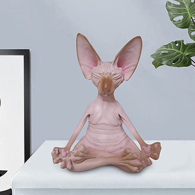 a sphynx cat sculptures doing meditation
