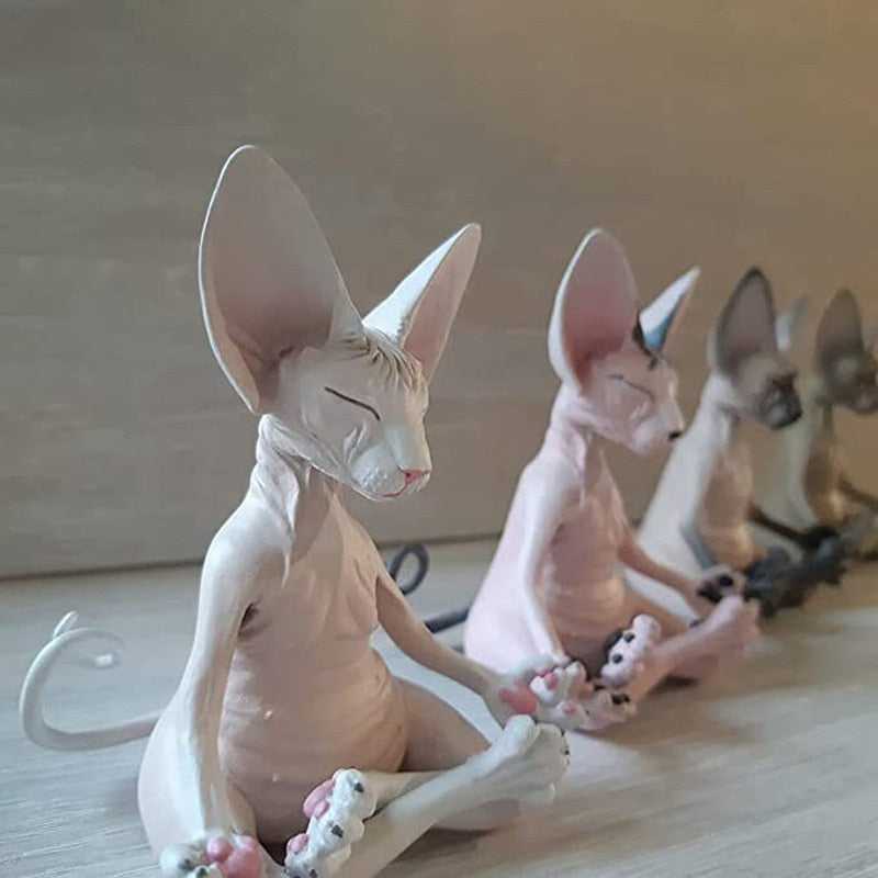 a collection of small sphynx cat statue doing meditation