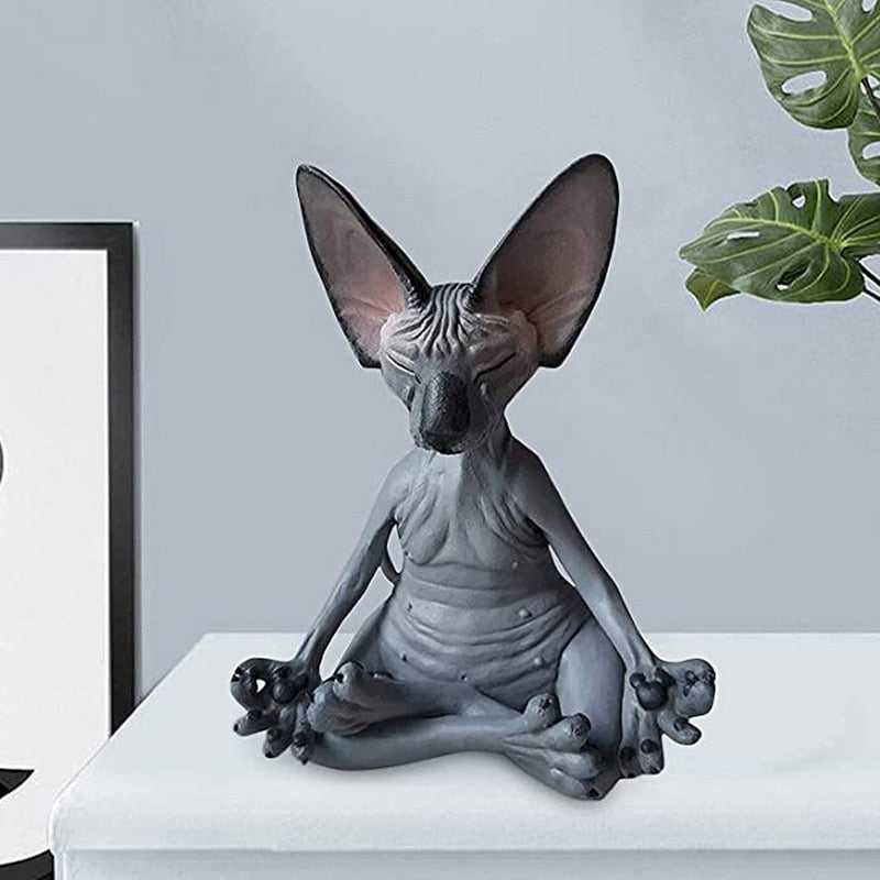 a sphynx black cat statue doing meditation