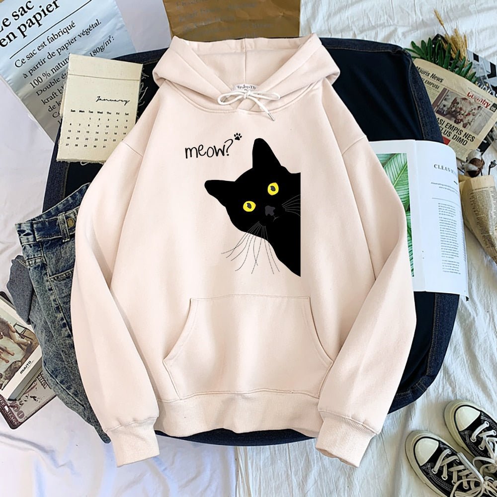 a beige color black cat hoodie featuring a humorous design of a sneaky black cat peeping from the corner with a funny 'Meow" caption