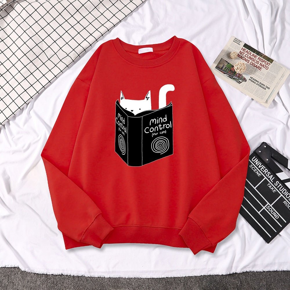 a red sweatshirts with cats on them reading a book about mind control