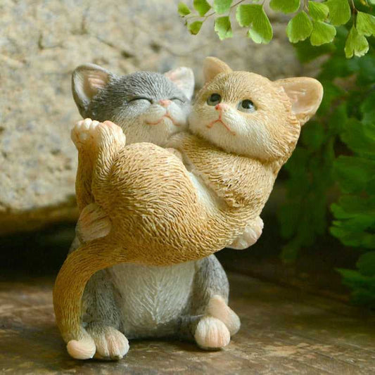 adorable cat figurine of a grey cat lifting an orange cat