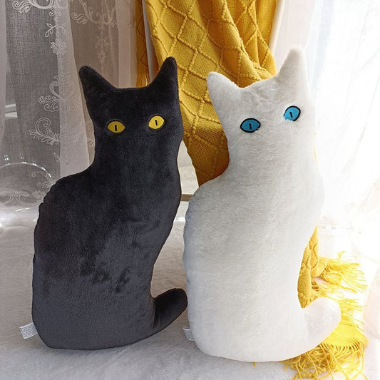 a black cat plushie and a white cat stuffed animal with minimal design