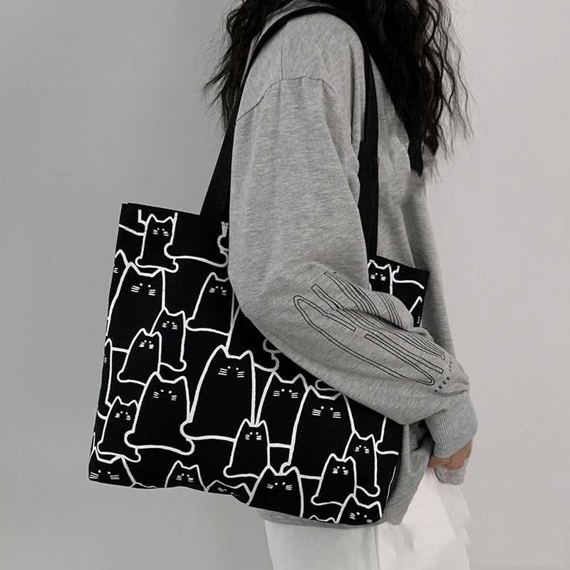 a lady carrying a black cat themed tote bag