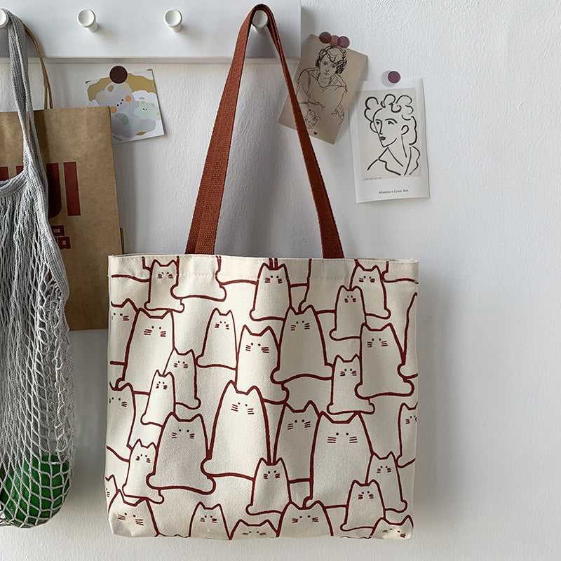 A cat themed tote bag hanging on the wall that looks so charming and cute