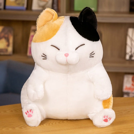 this is a calico cat plush on a table