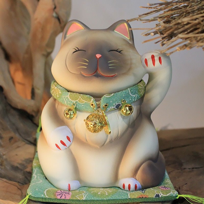 a white lucky cat sculpture with necklace and bell for home decor