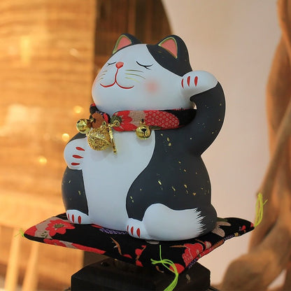 a black lucky cat statue with bells and matt for decor
