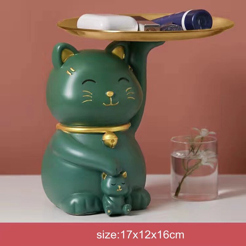 a green color cat figure holding a tray and a baby for home decor and putting personal itmes