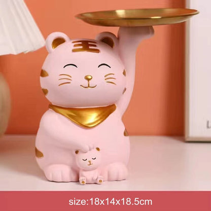 a pink color cat statue with stripes holding a tray for personal items