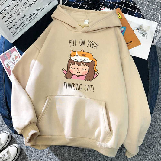 beige color cat hoodie with a picture of a little girl with a cat on top of her head with the pun of thinking cat that looks cute and adorable