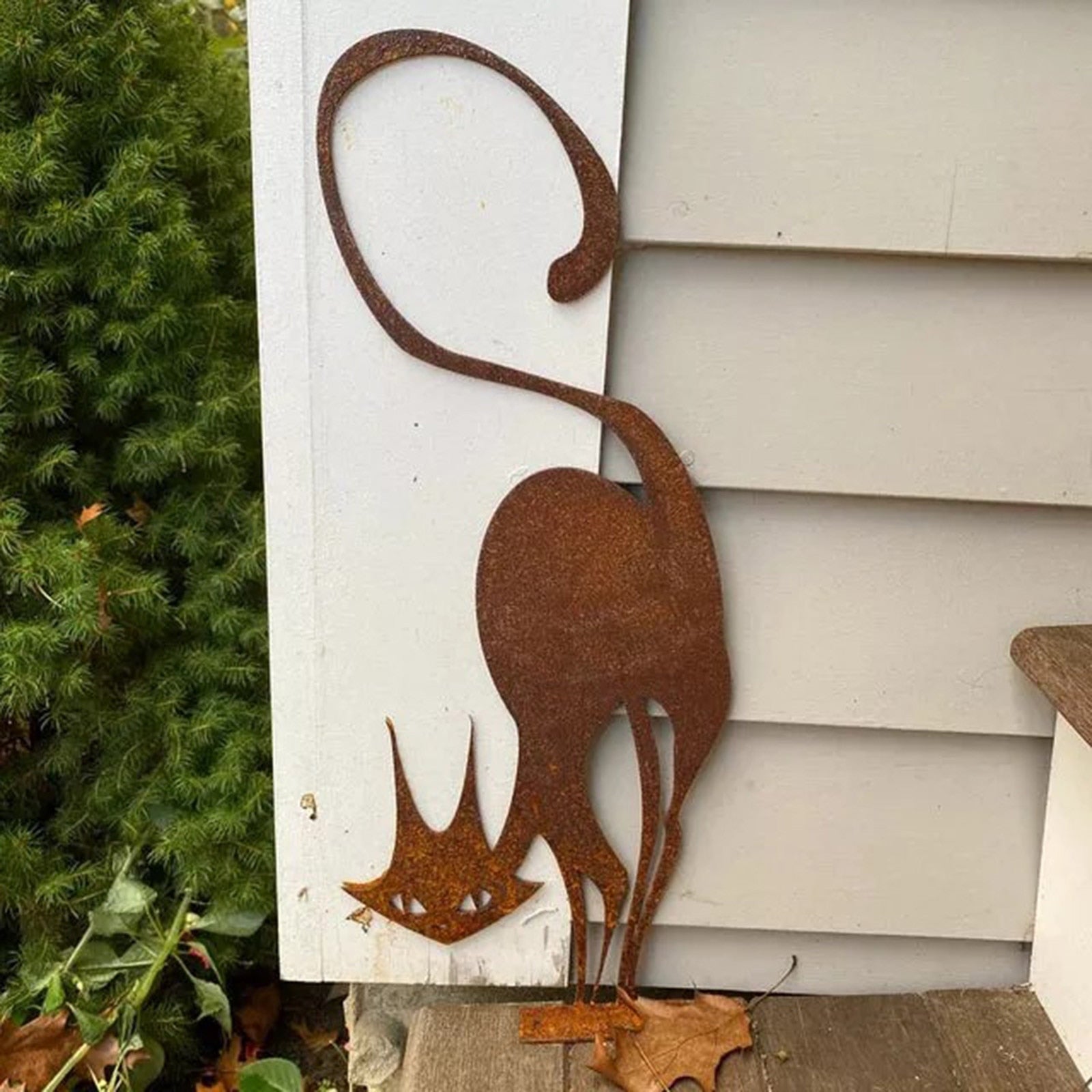an outdoor cat statue of a freaky cat made from rusty metal for garden decor