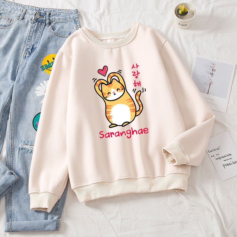 beige kawaii cat sweater for woman featuring a cat making a heart with the arms