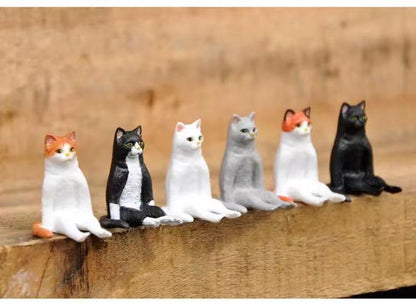 a set of small cat sculptures of a cat in sitting position