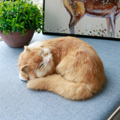 an orange realistic cat plush of a sleeping cat