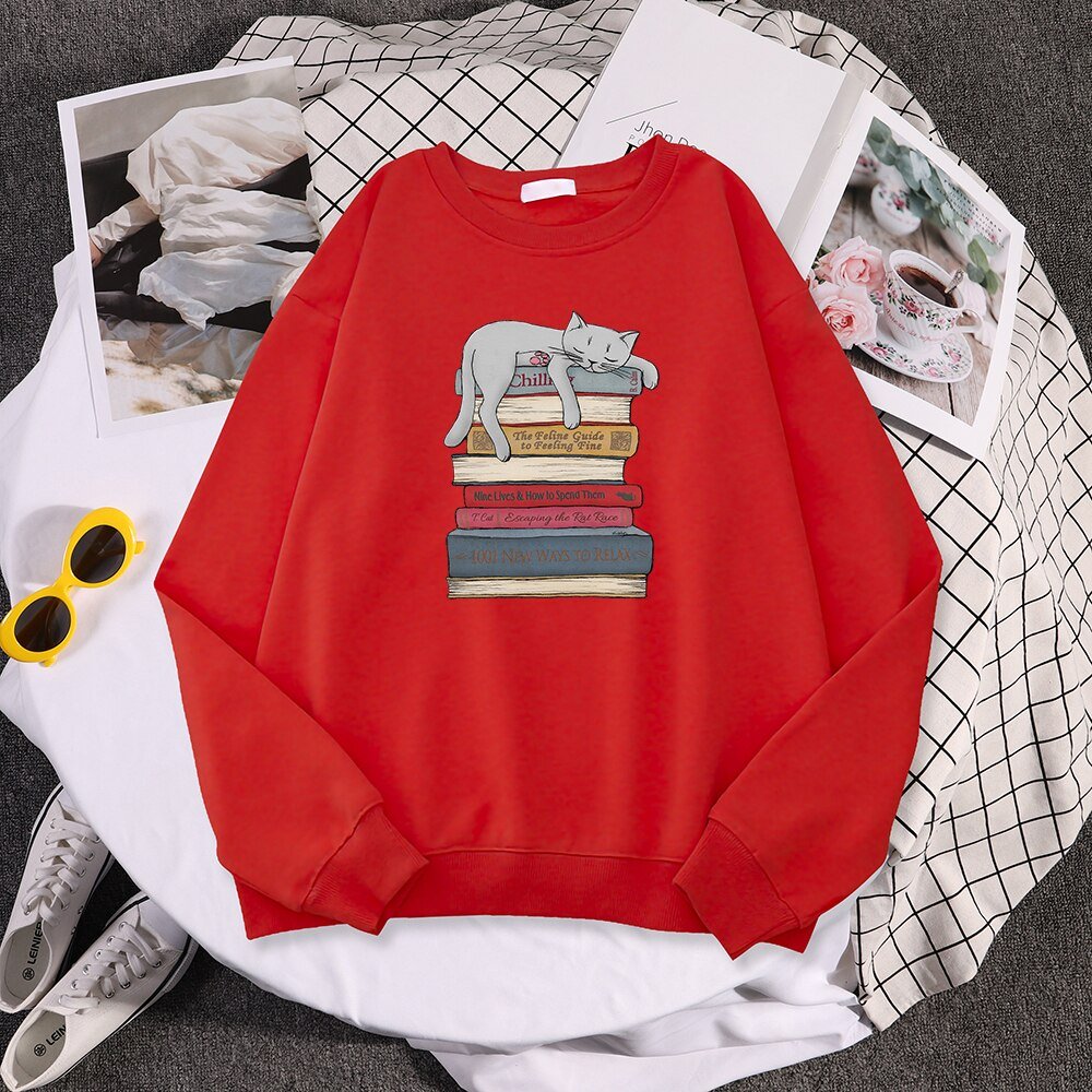 a red funny cat sweatshirts with a picture of a cat sleeping on a stack of books