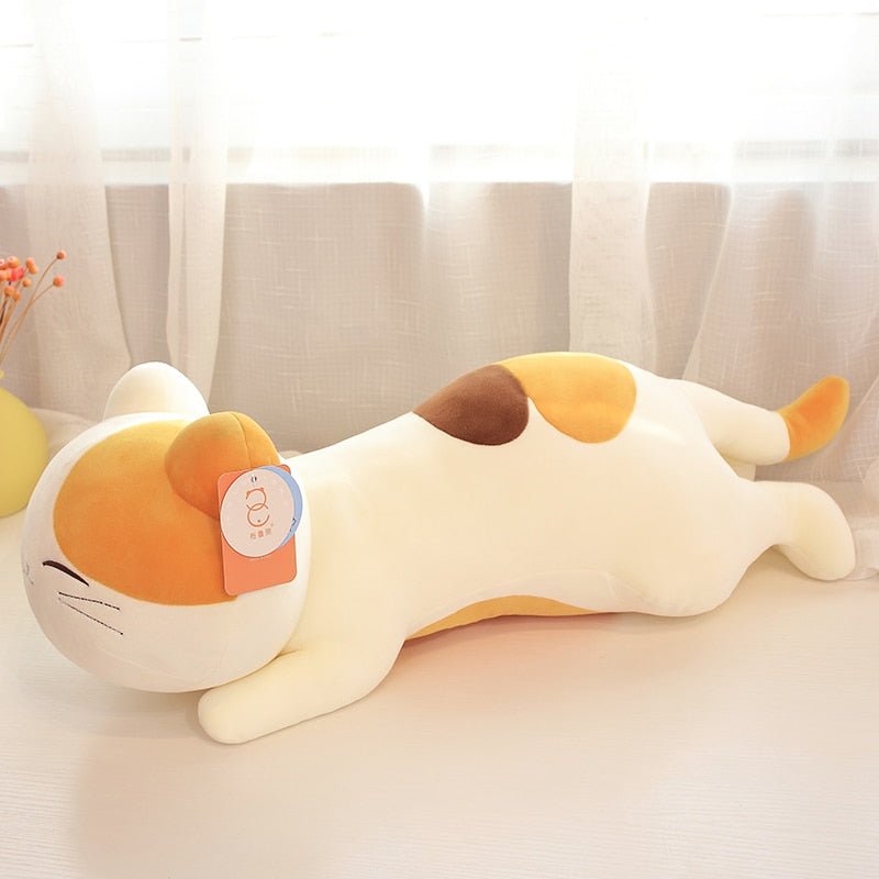 a giant cat plush of a calico cat at home