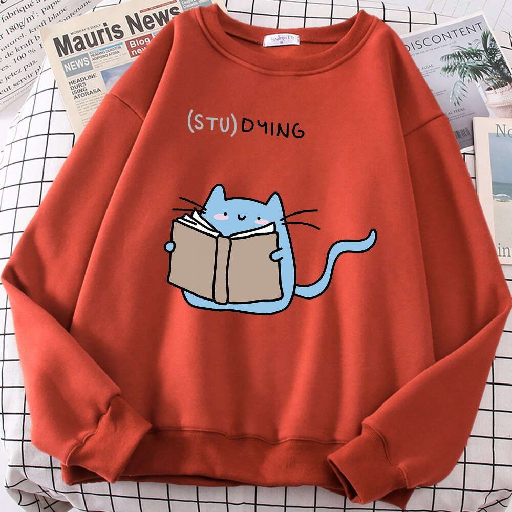 a red color cat themed sweatshirt with a picture of a cat reading a book