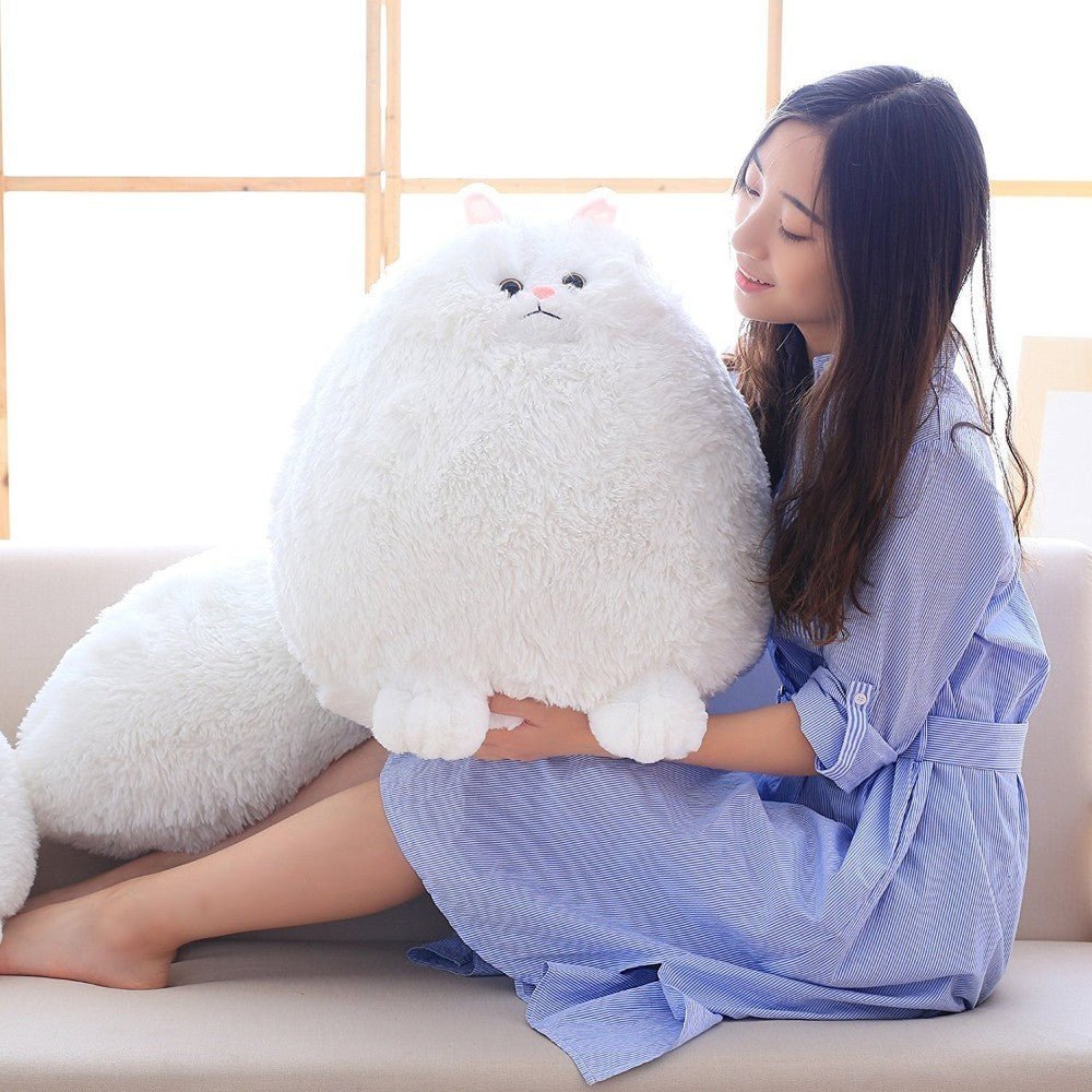 a lady with a white cat stuffed animal that is soft and fluffy