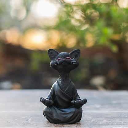 a black cat sculptures featuring a cat doing yoga meditation in a robe