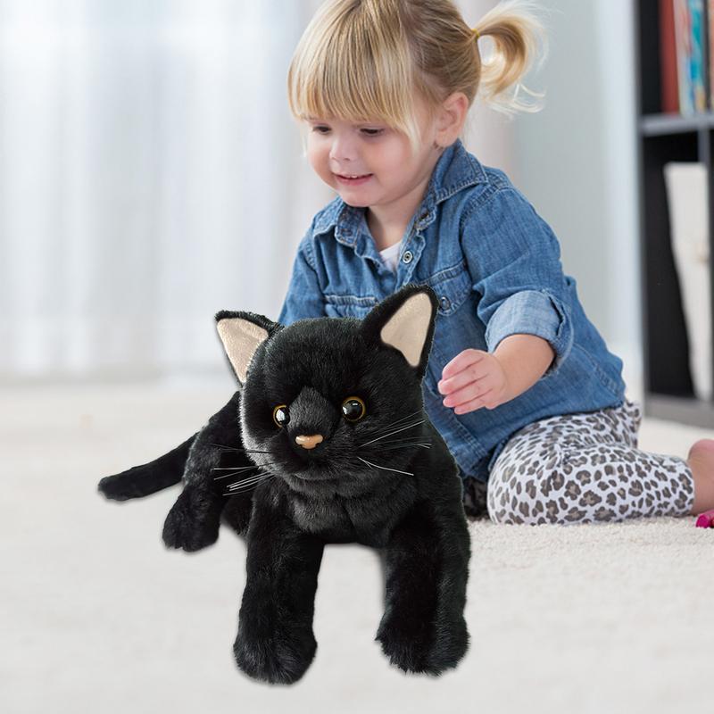a baby playing with a black cat plushie