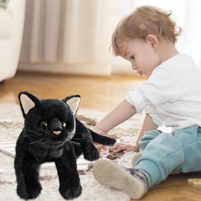 a baby playing with a realistic cat plush