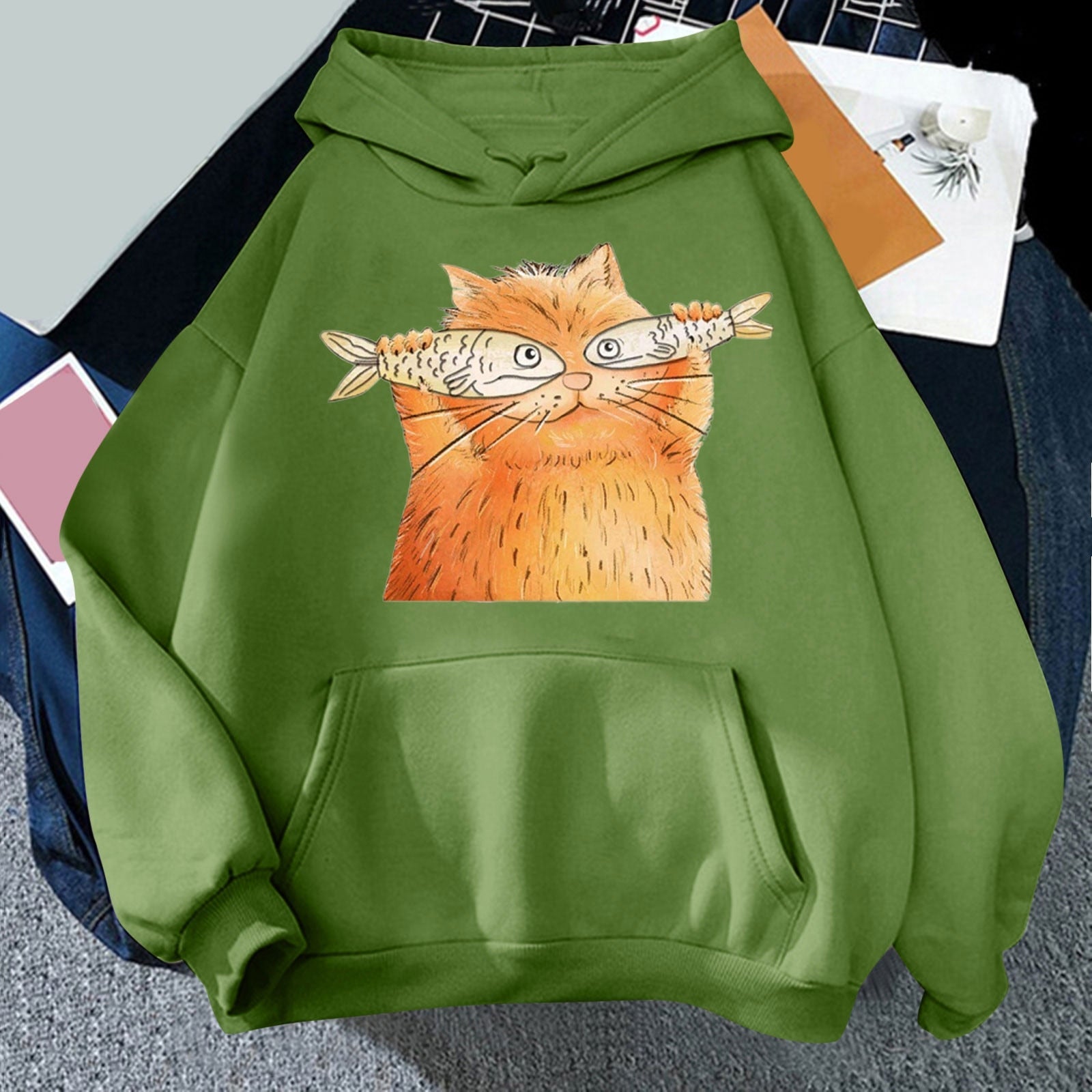green color hoodie for women printed with a ginger cartoon cat holding two fishes and look really funny and hilarious