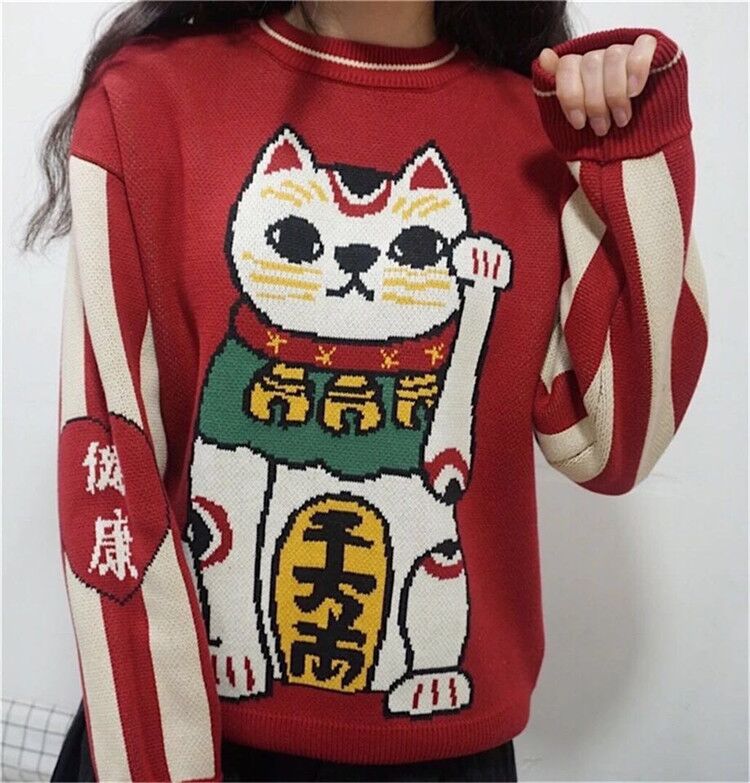a lady wearing a cute cat sweaters with a picture of a lucky cat
