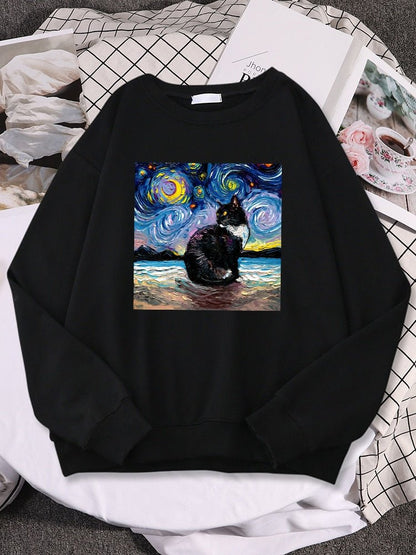a black color black cat sweatshirt with picture of a cat and starry night