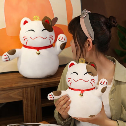 a lady holding a pillow cat plush of a lucky cat