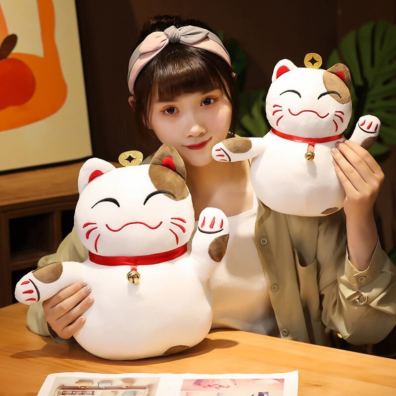 a lady holding cute plushies of a lucky cat
